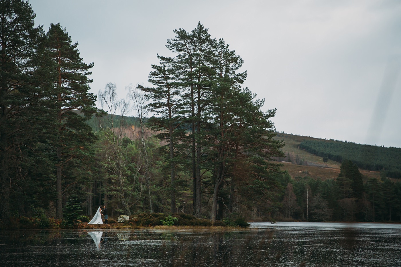 wide shot of loch and newlyweds at a Christmas wedding at Glen Tanar
