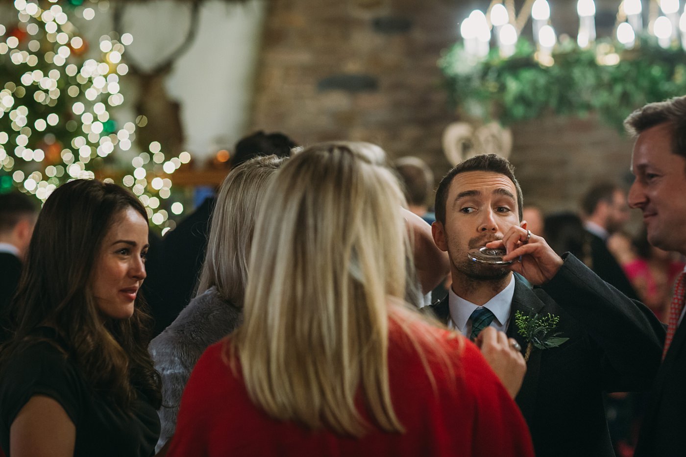 groom drinks from hip flask at a Christmas wedding at Glen Tanar
