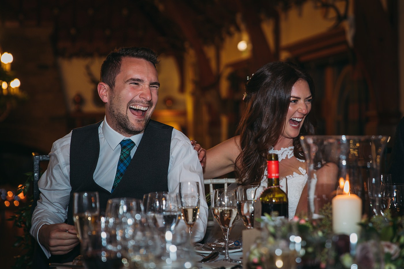 bride and groom laugh during speeches at their Christmas wedding at Glen Tanar