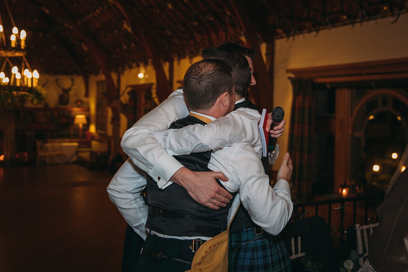 groom hugs his best men at his Christmas wedding at Glen Tanar