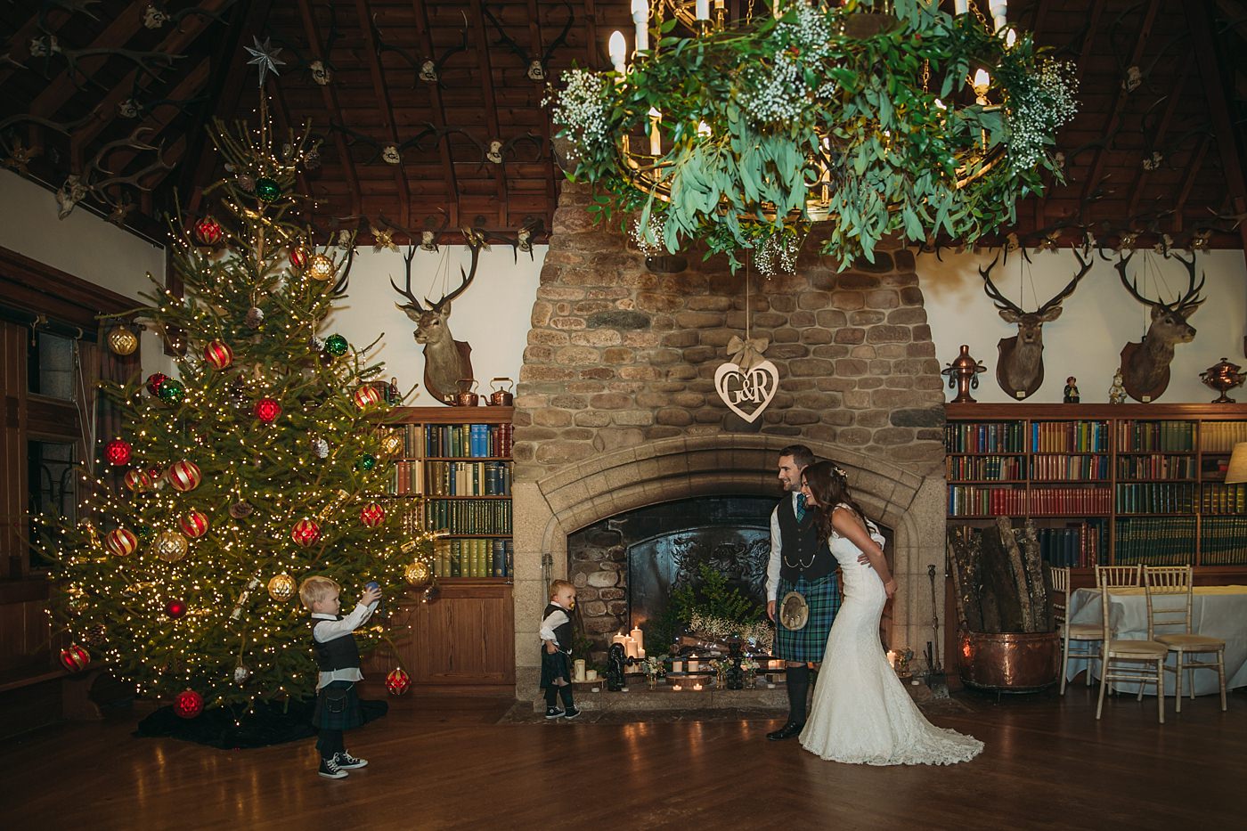 bride and groom have their photo taken by their nephew at their Christmas wedding at Glen Tanar