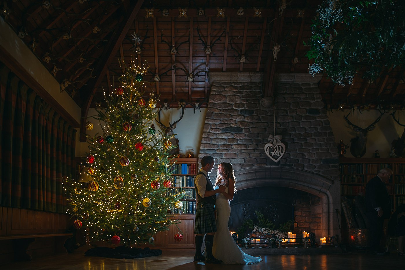 bride and groom with Christmas tree at their Christmas wedding at Glen Tanar