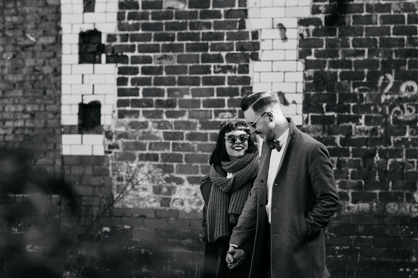 A black and white photo of Bygone Photobooth Company Owners Joe & Steph walking near the Glue Factory in Glasgow