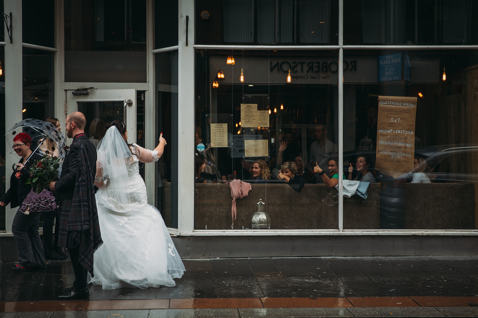 best wedding photographs of newlyweds getting thumbs up from people in the street in Glasgow