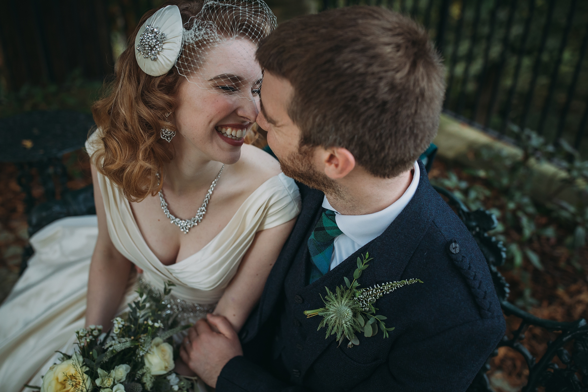 Crossbasket Castle best wedding photographs - newlyweds laugh together on bench