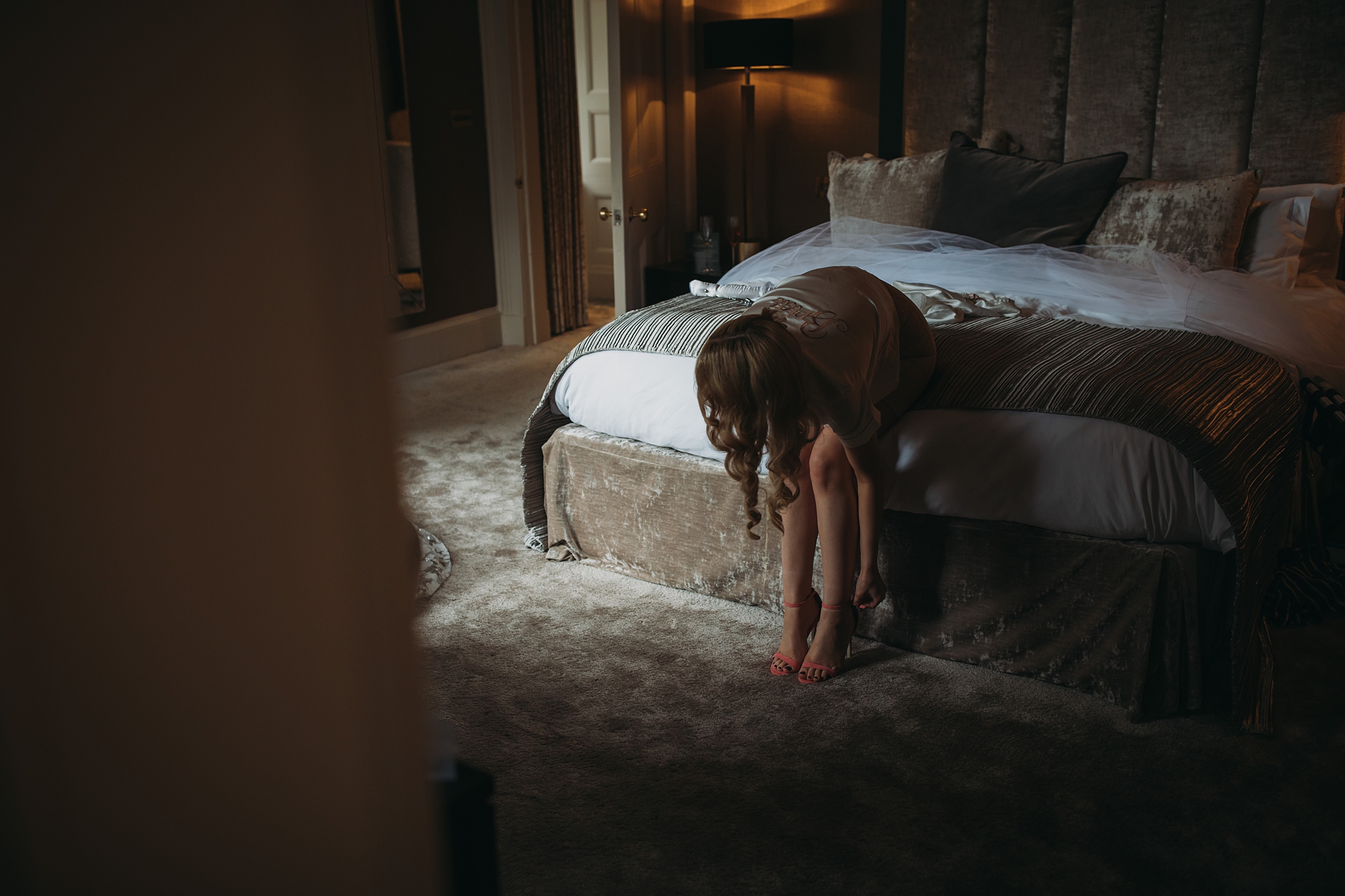 best wedding photographs - bride puts on her shoes in the window light