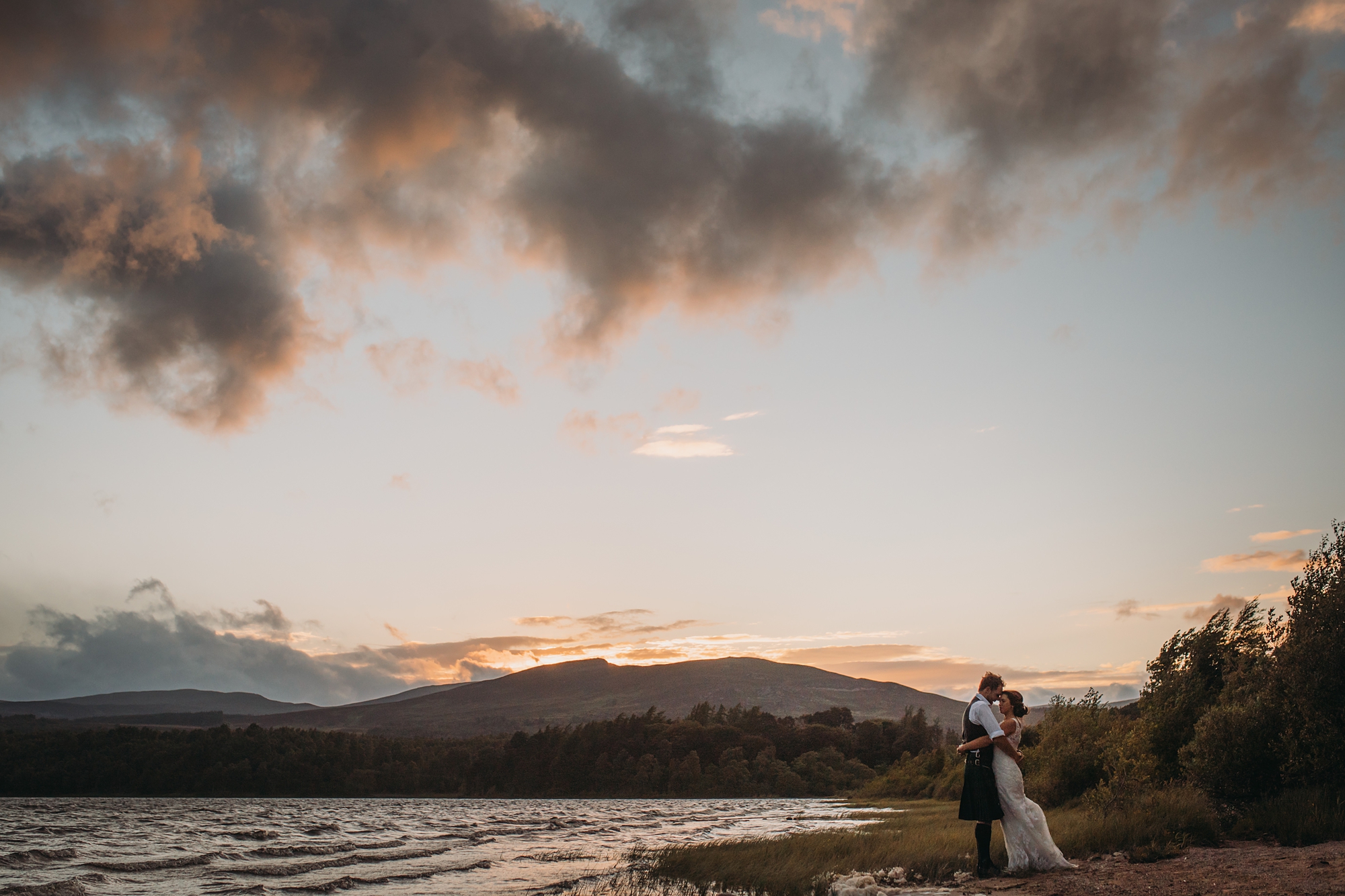 best wedding photographs a couple embrace in the sunset at Loch Insh