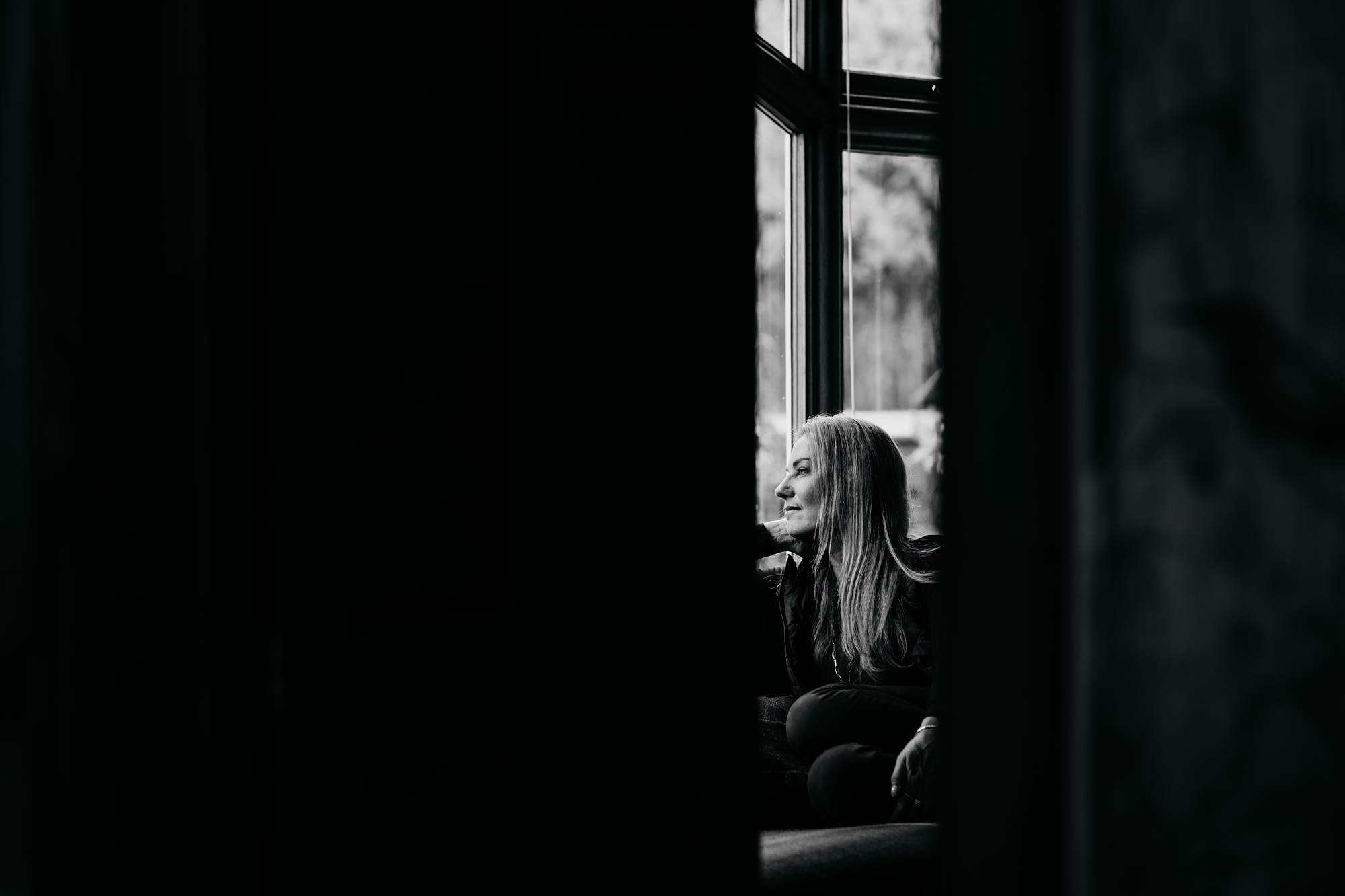 Grooms mother looks out the window - best wedding photographs