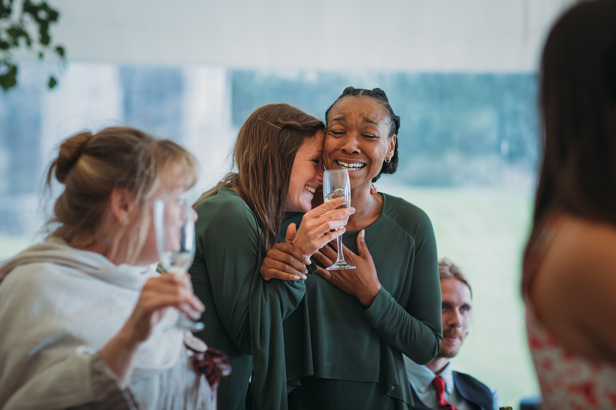 Two bridesmaids cry and laugh together - best wedding photographs