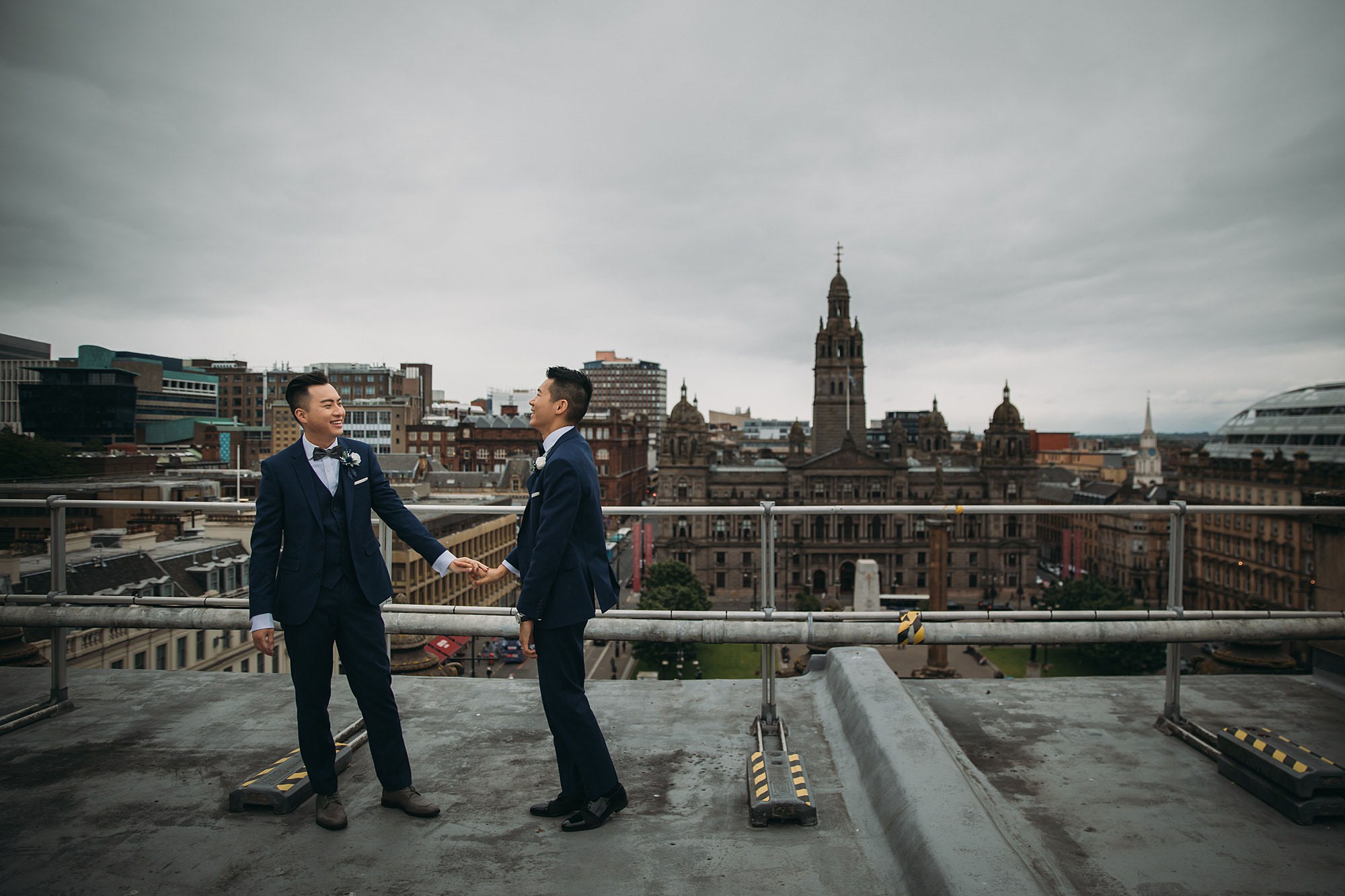Two grooms enjoy the city views during their Glasgow elopement.