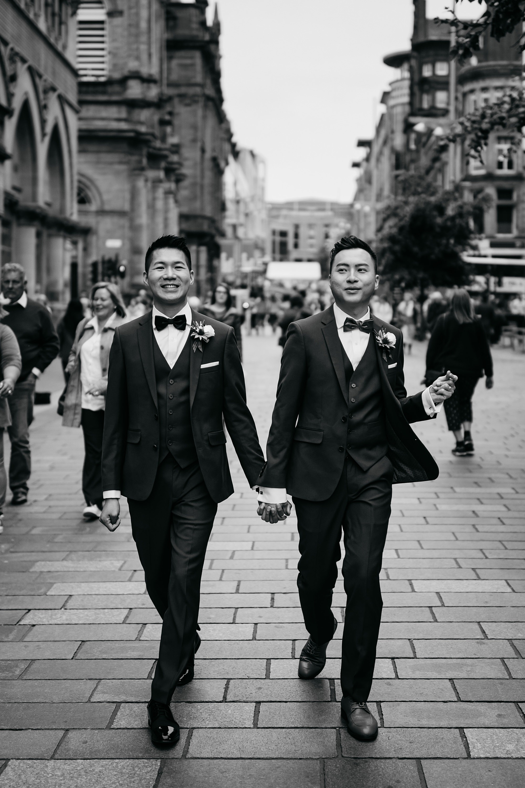 Two grooms, just married, walk down Buchanan Street during their Glasgow elopement.