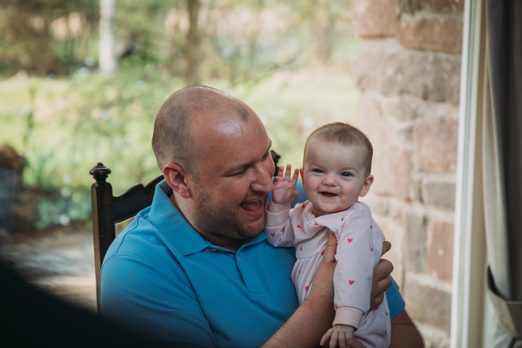 Groom laughs with a baby at his High Wards wedding