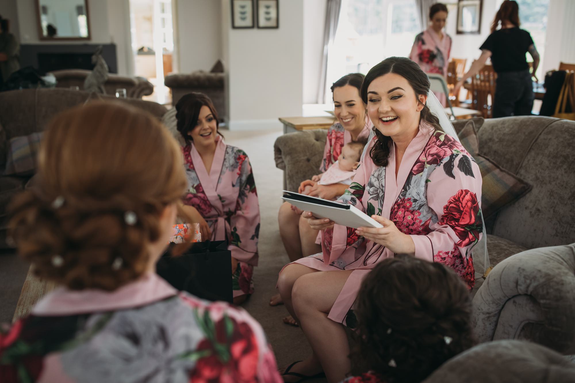 bride opens gift from her bridesmaids on the morning of her High Wards wedding