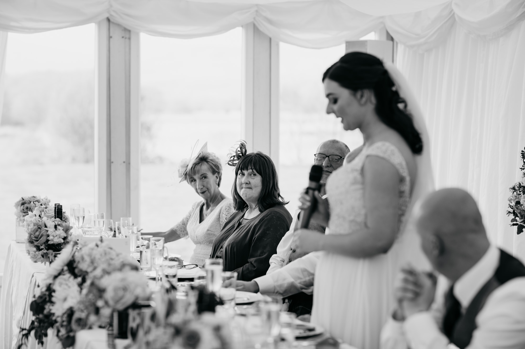 Mother of the Bride looks proudly at her daughter as she gives a speech at her High Wards wedding