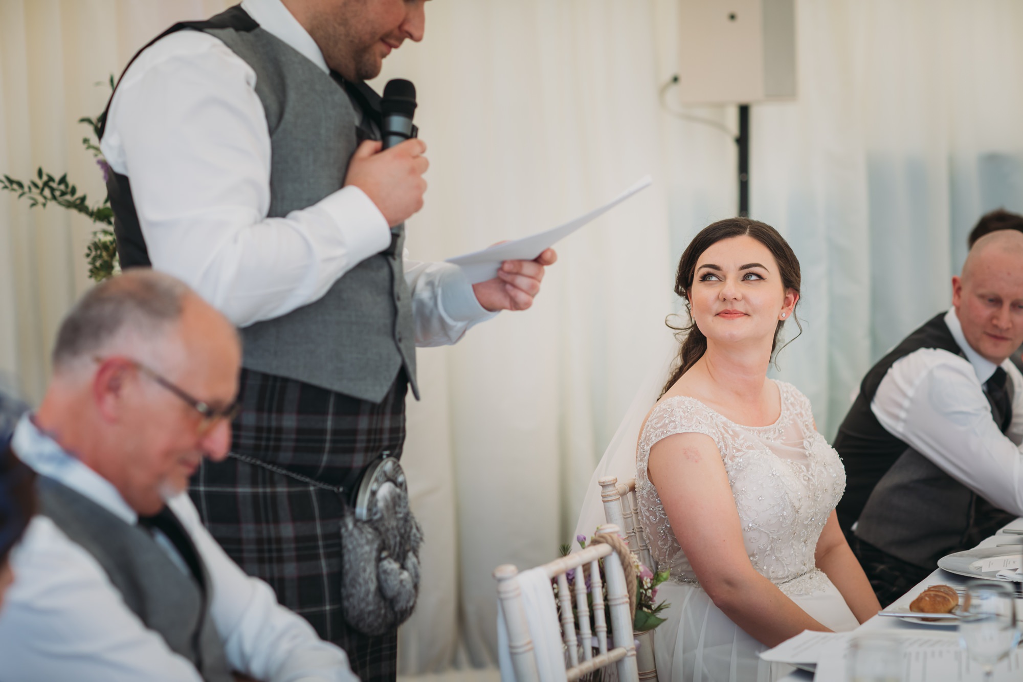 bride looks lovingly at her husband during his High Wards wedding speech