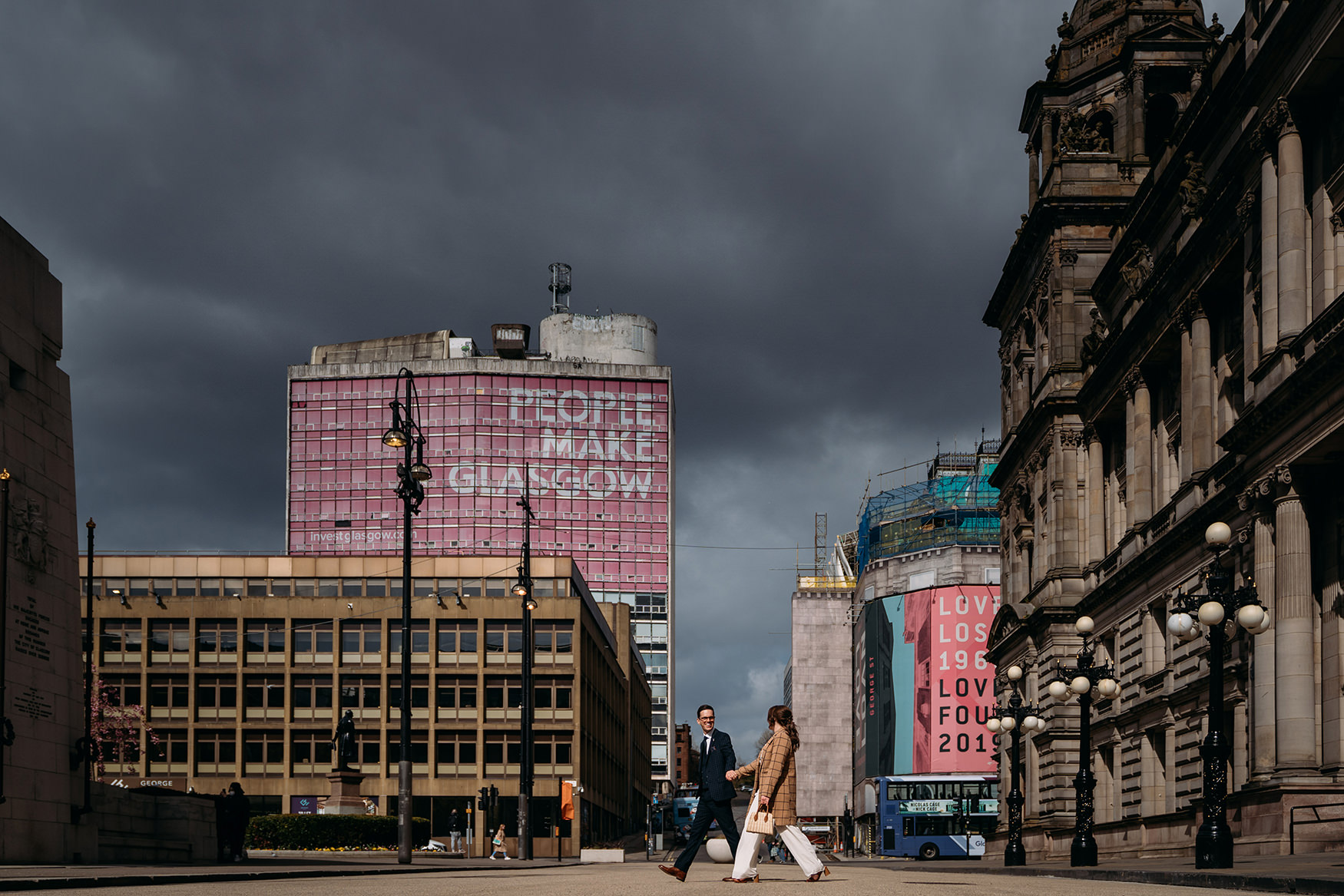 Glasgow City Chambers Wedding couple walk past people make Glasgow sign