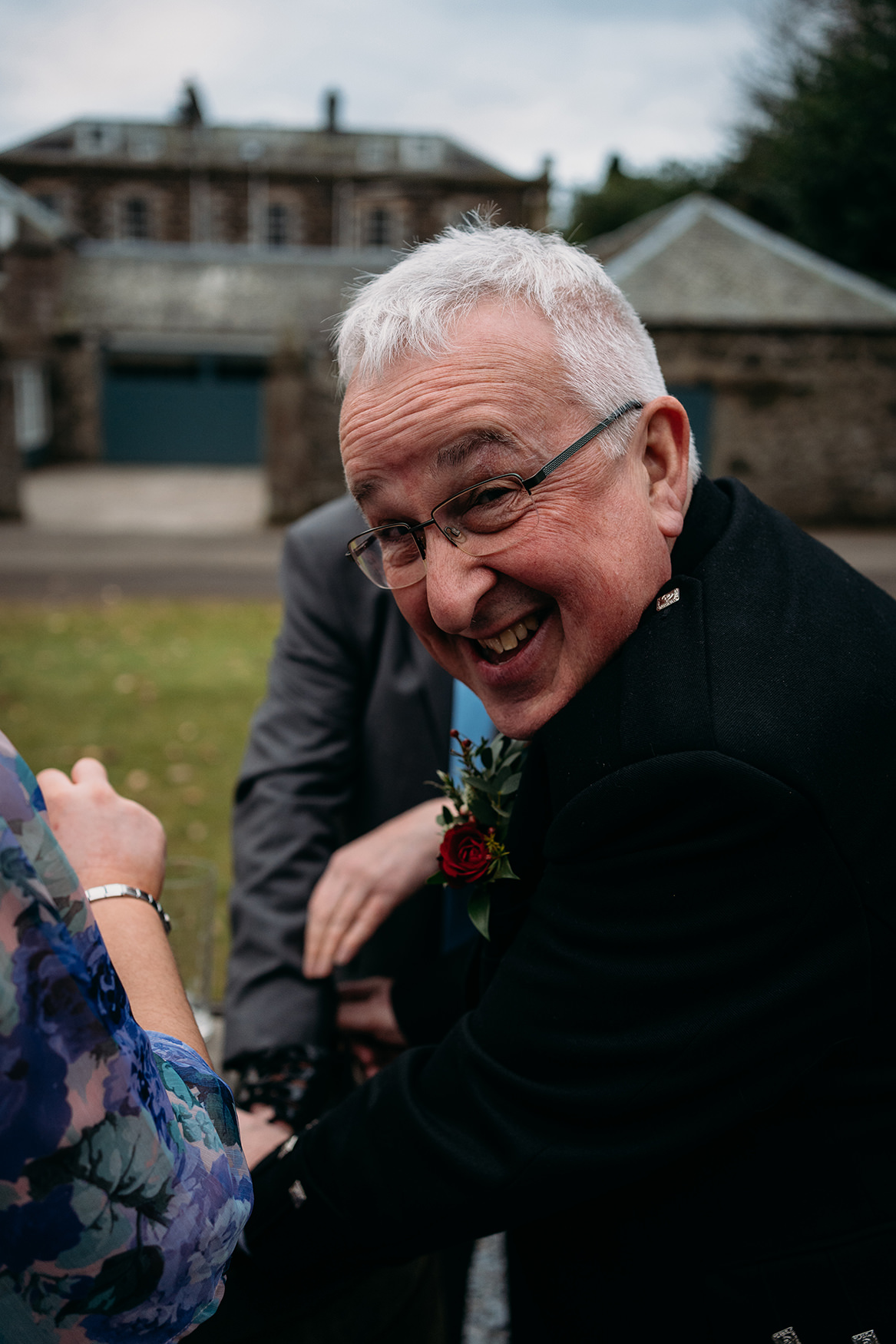 man laughing at his broken kilt shoe on wedding day