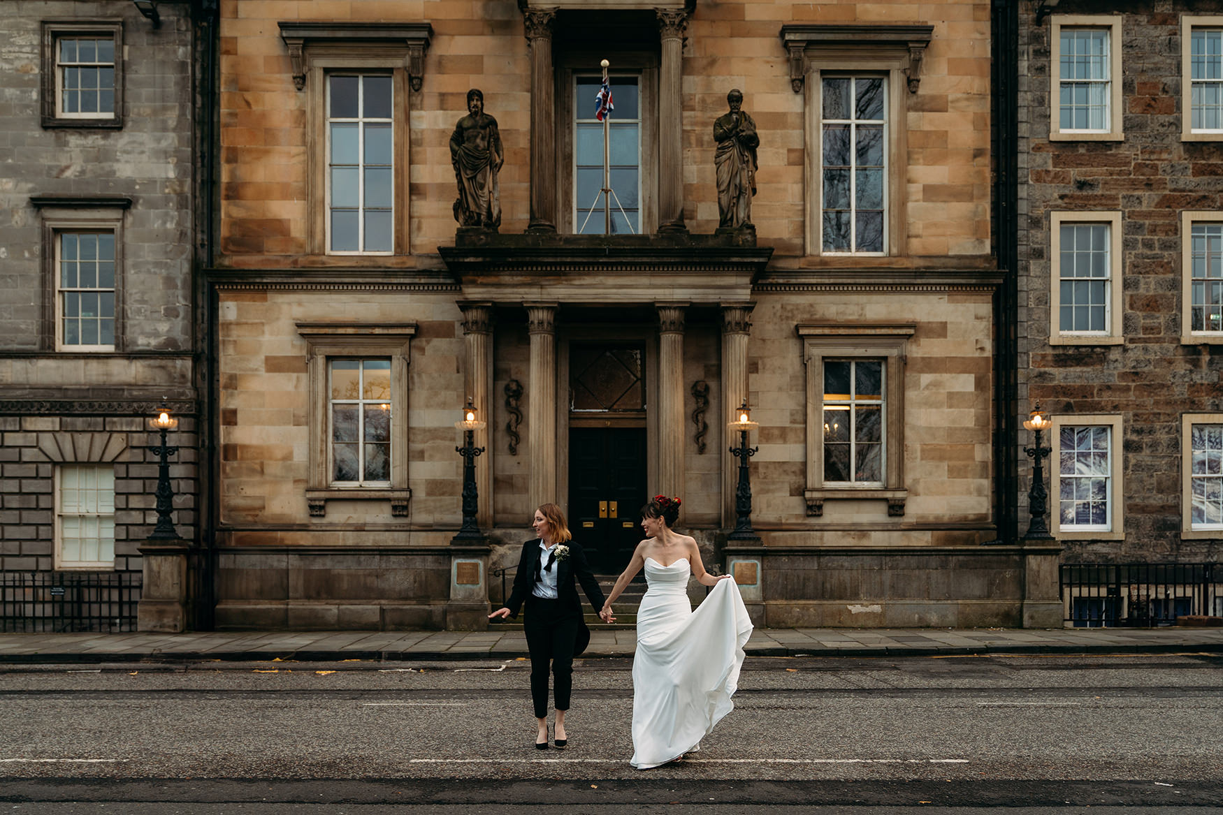 two brides cross street at Royal College of Physicians Wedding Edinburgh