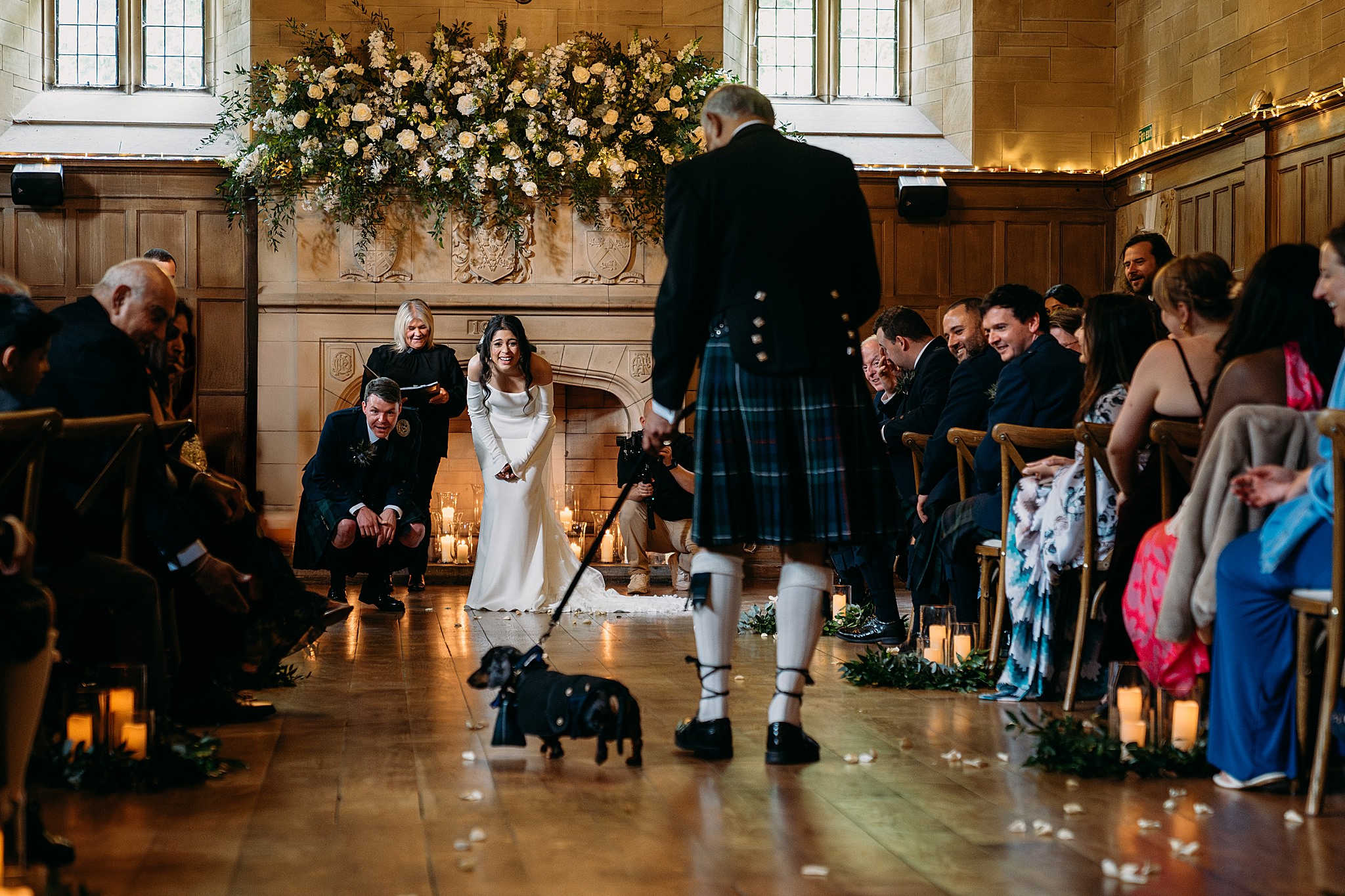 Bride and grooms dog walks down aisle , everyone looks delighted at Indo-Scottish Achnagairn Castle wedding