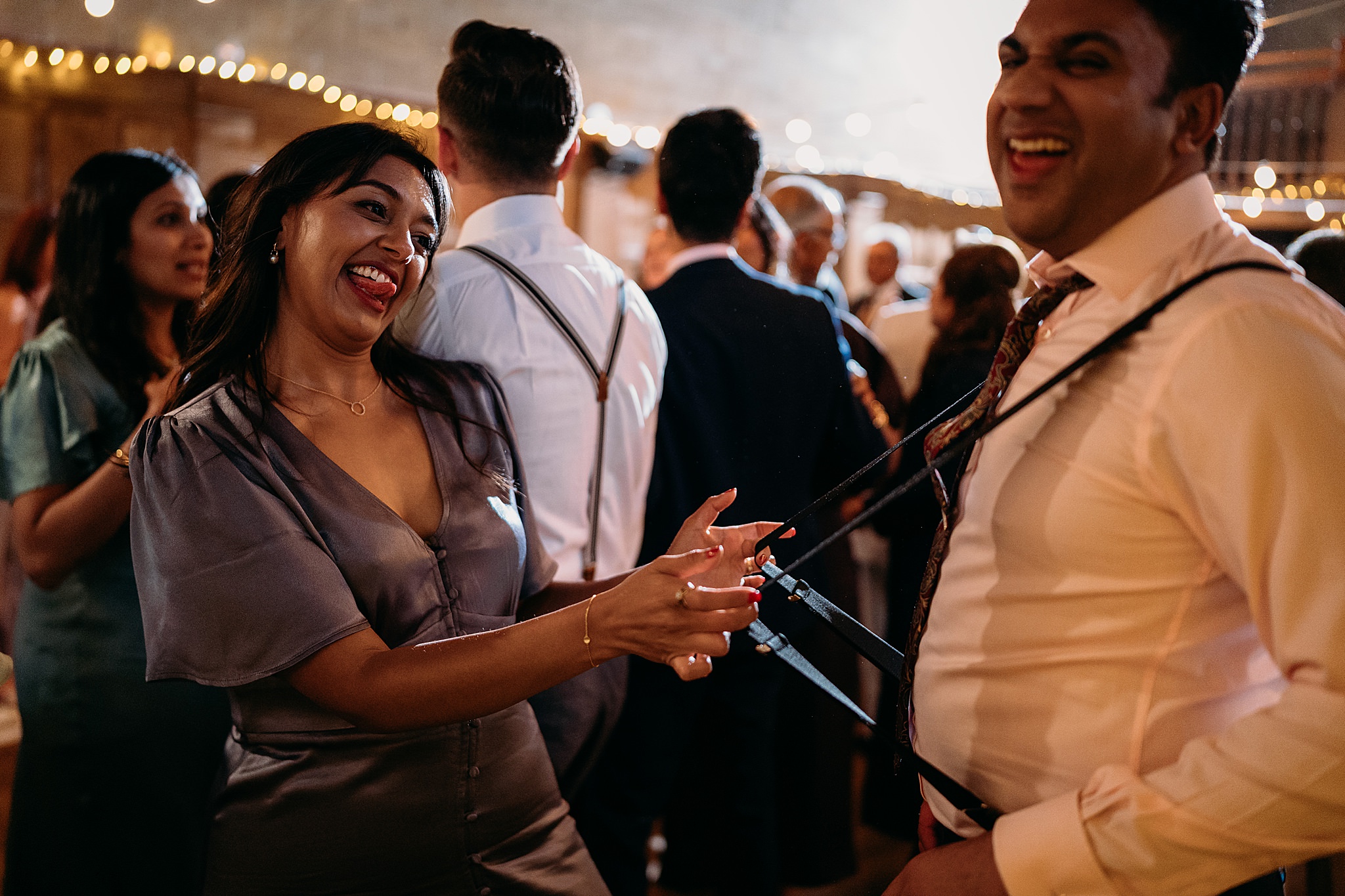 Girl pulls boyfriends braces on dancefloor at Indo-Scottish Achnagairn Castle wedding