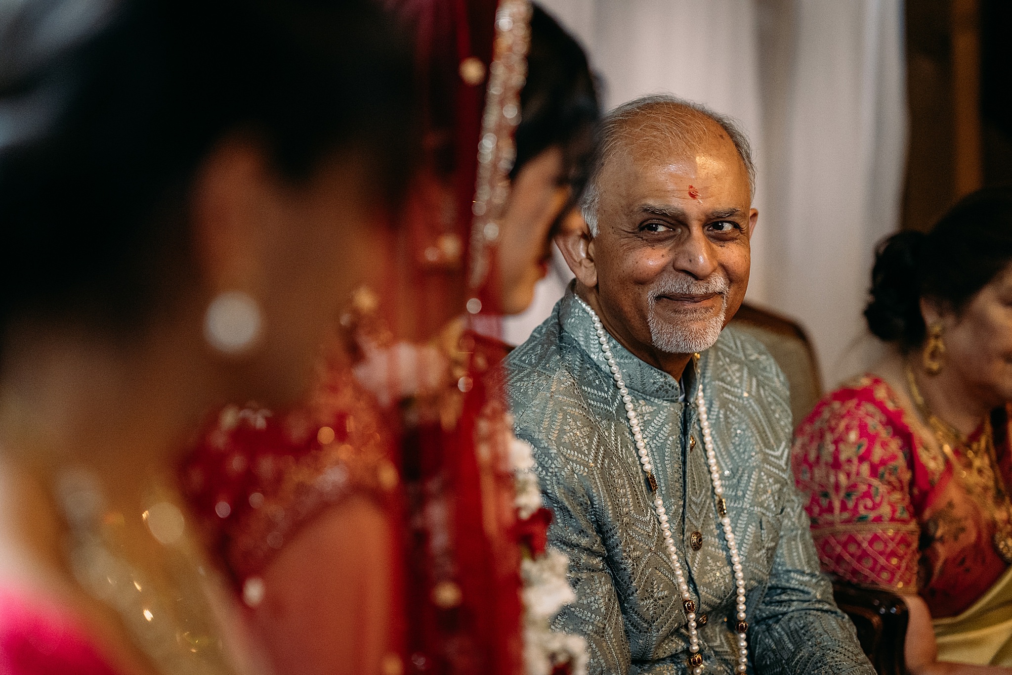 Dad looks lovingly ay daughter during Indo-Scottish Achnagairn Castle wedding ceremony