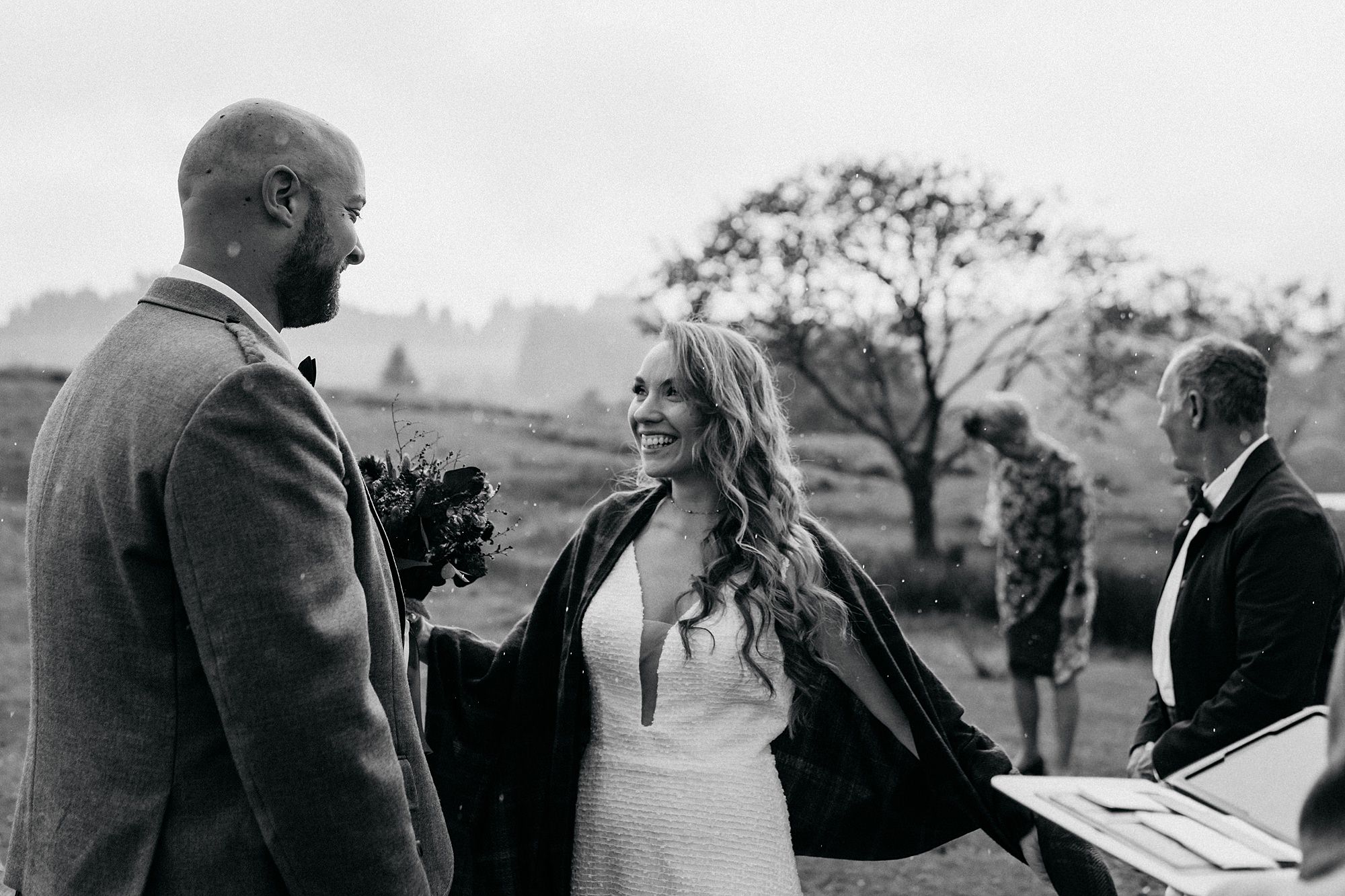 Bride and groom share look during Glencoe elopement as it rains. relaxed wedding photography