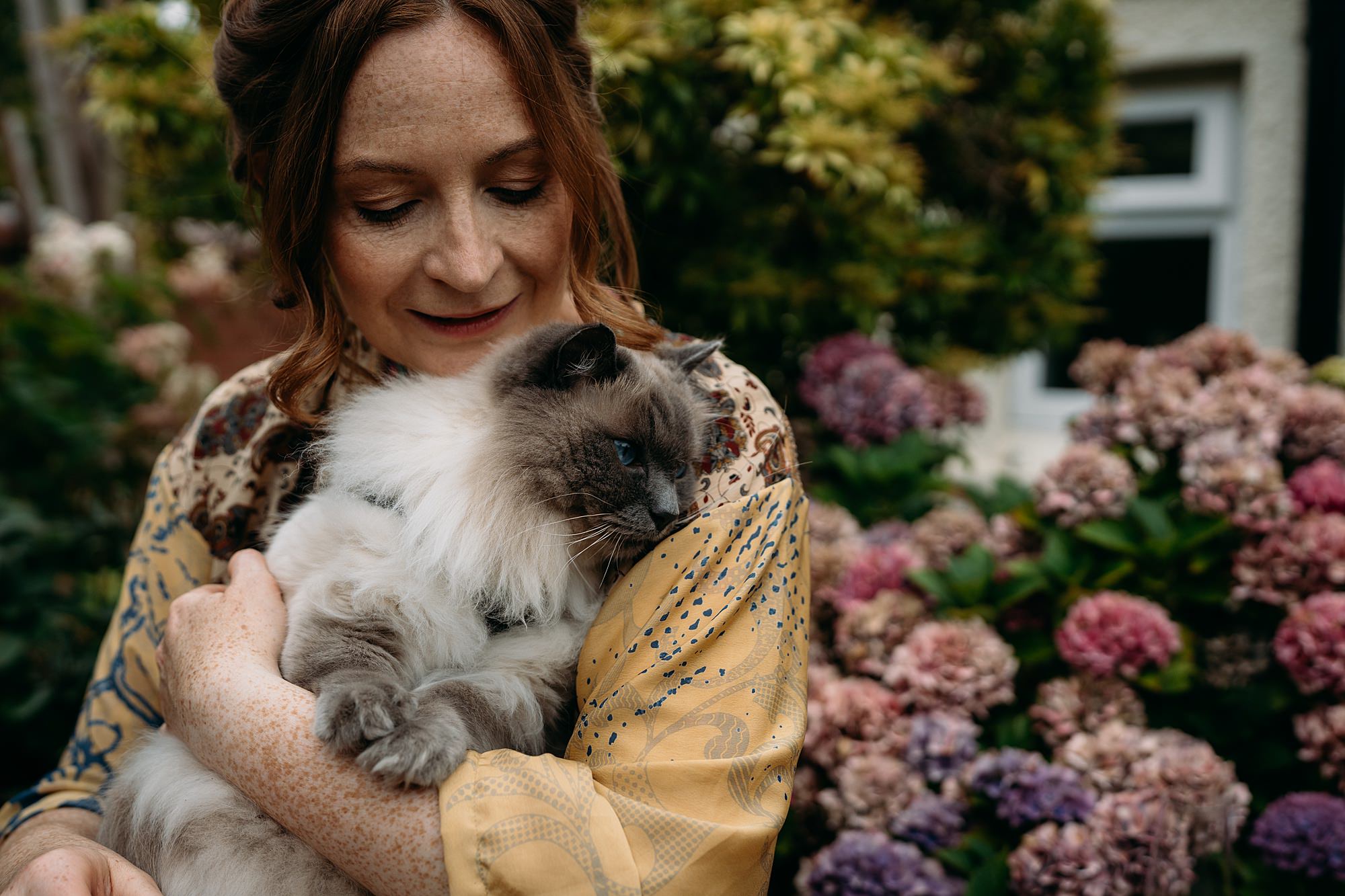 Relaxed wedding photography of a bride hugging her cat in Glasgow