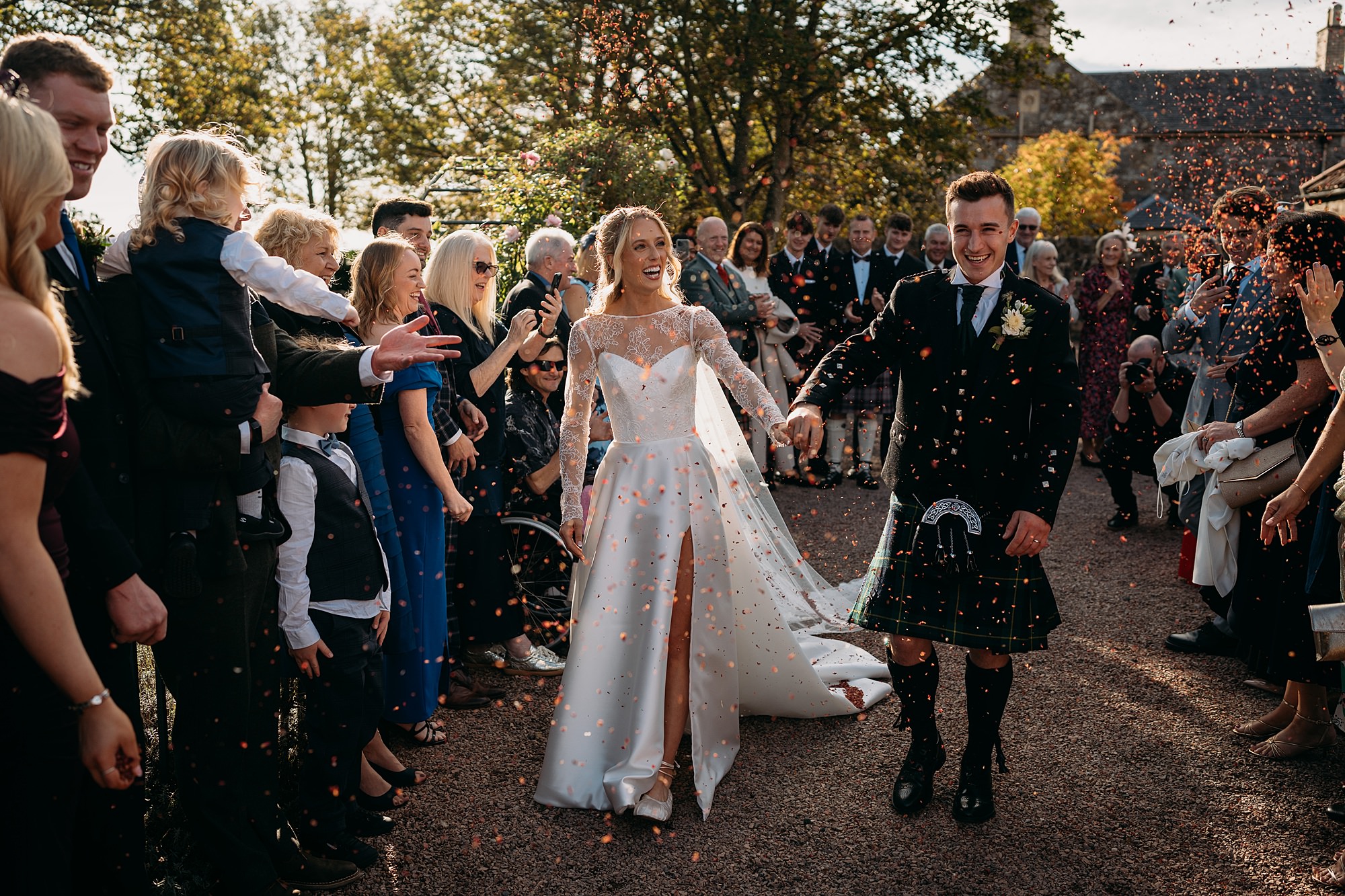 Relaxed wedding photography of a couple walking through confetti at The Rhynd