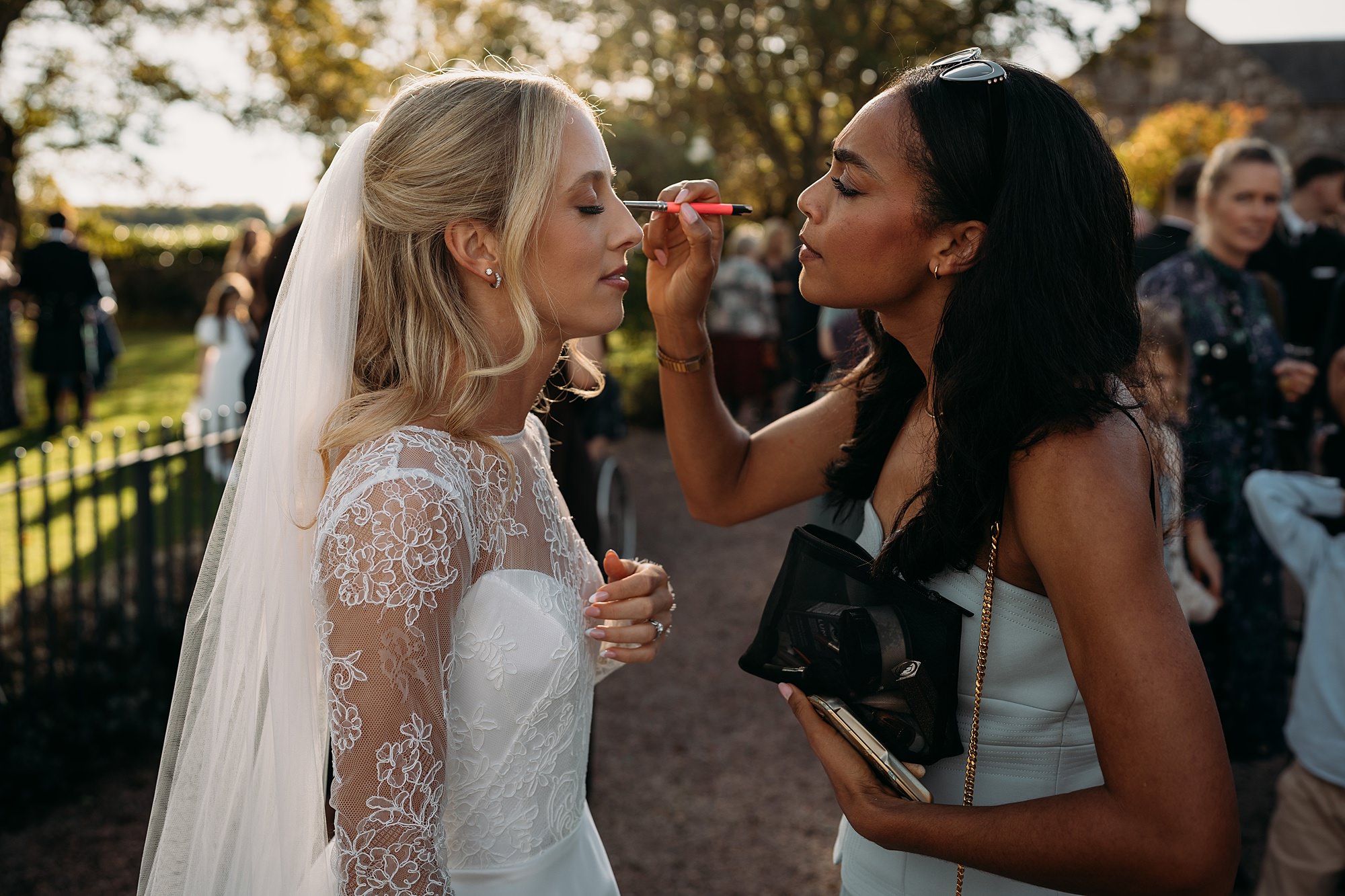 Friend fixes Jemma Reekie's makeup at her wedding. Relaxed wedding photography at The Rhynd.