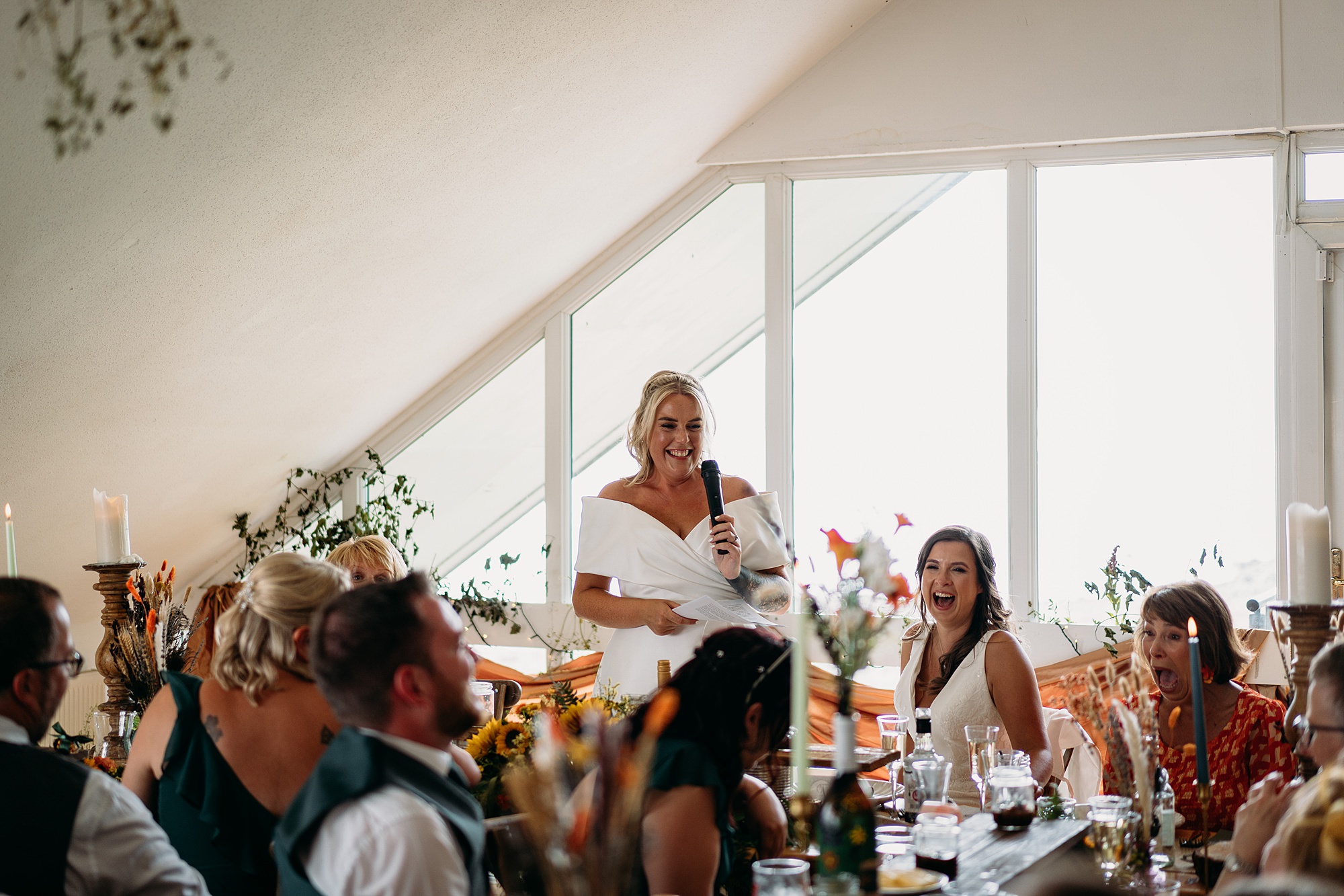 Two brides at their Venachar Lochside wedding during speeches. Relaxed wedding photography, queer friendly. 