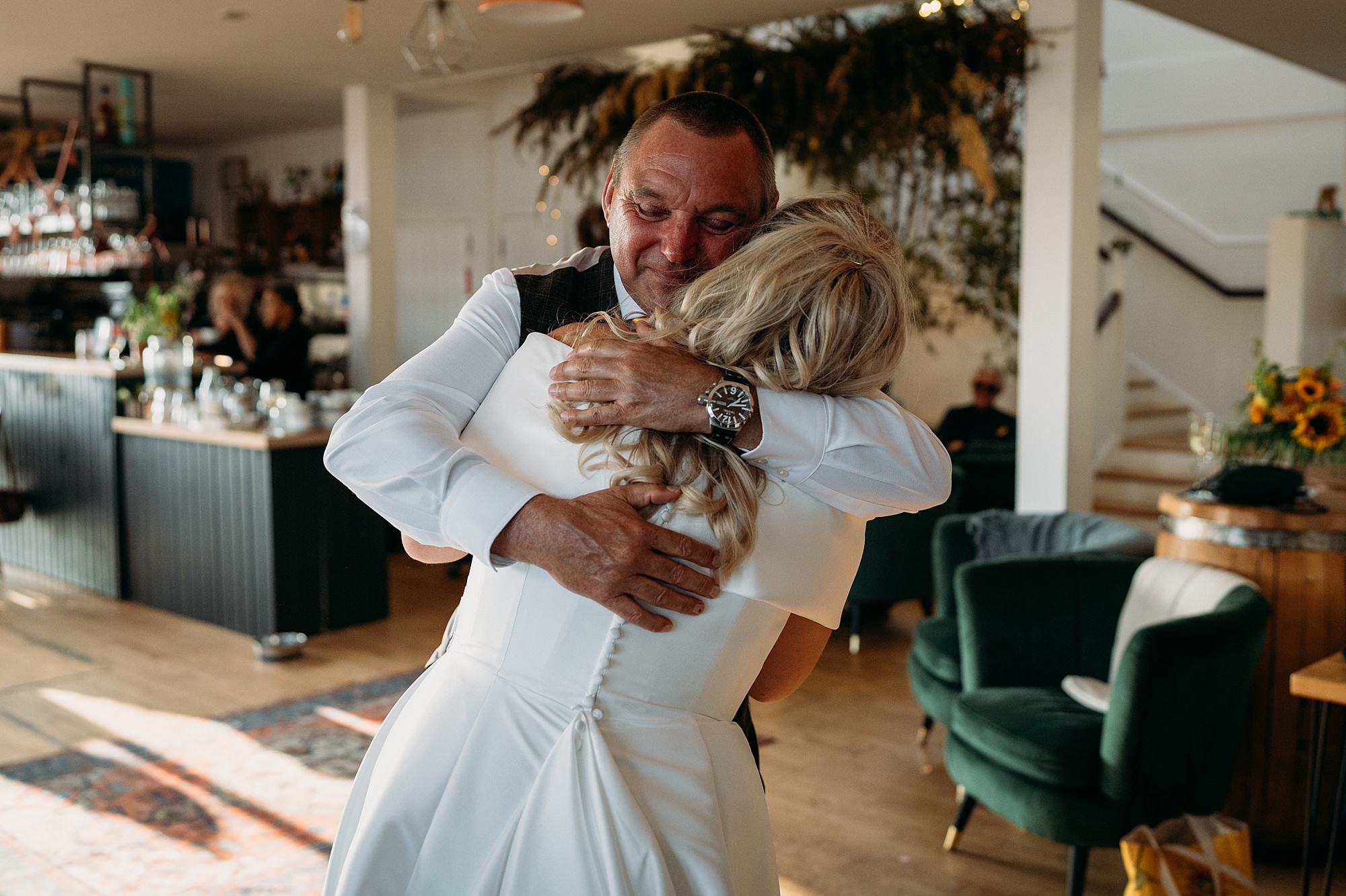 A dad hugs his daughter at Venachar Lochside, Relaxed wedding photography