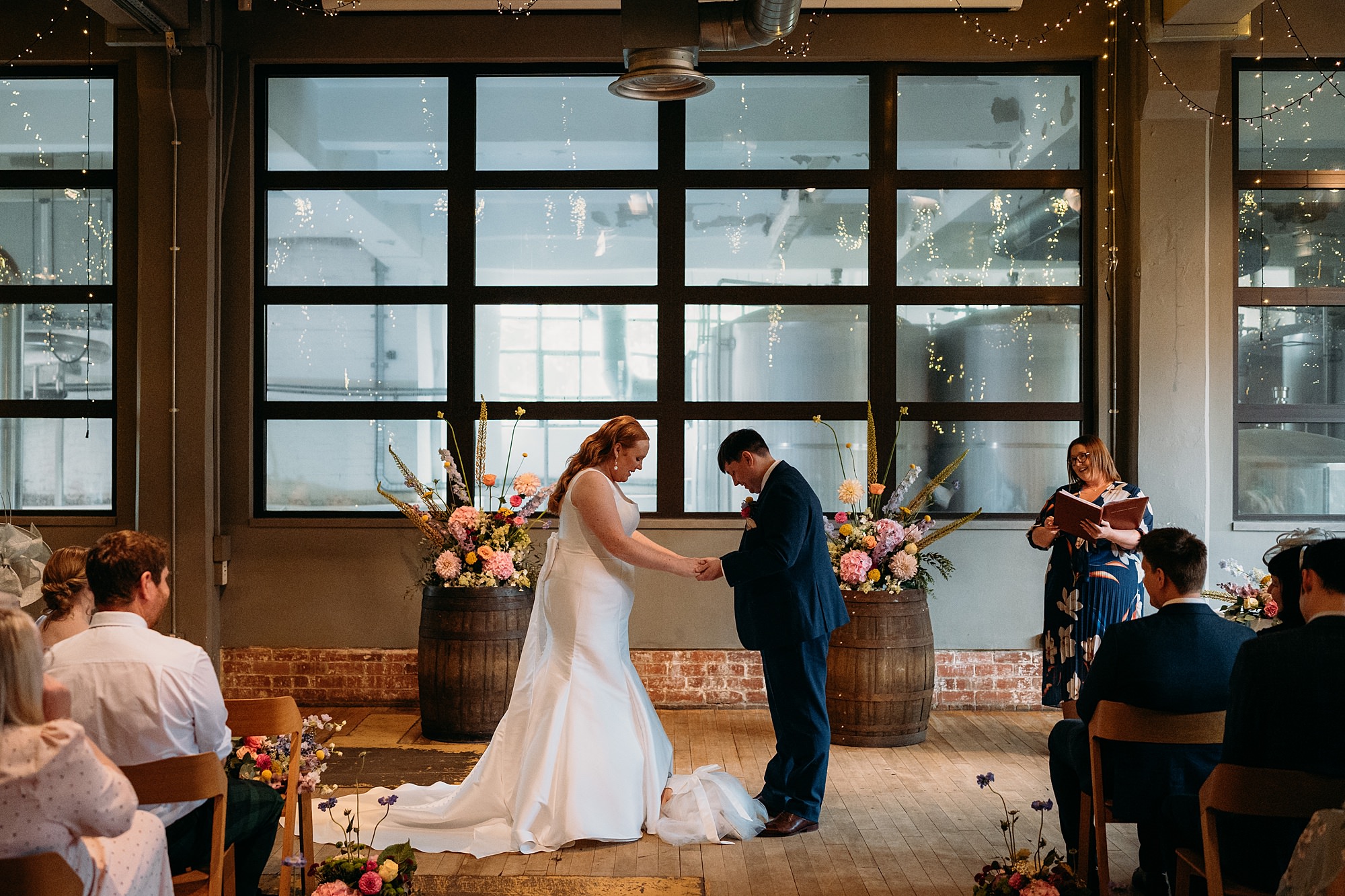 little girl falls asleep under brides dress at relaxed WEST brewery wedding