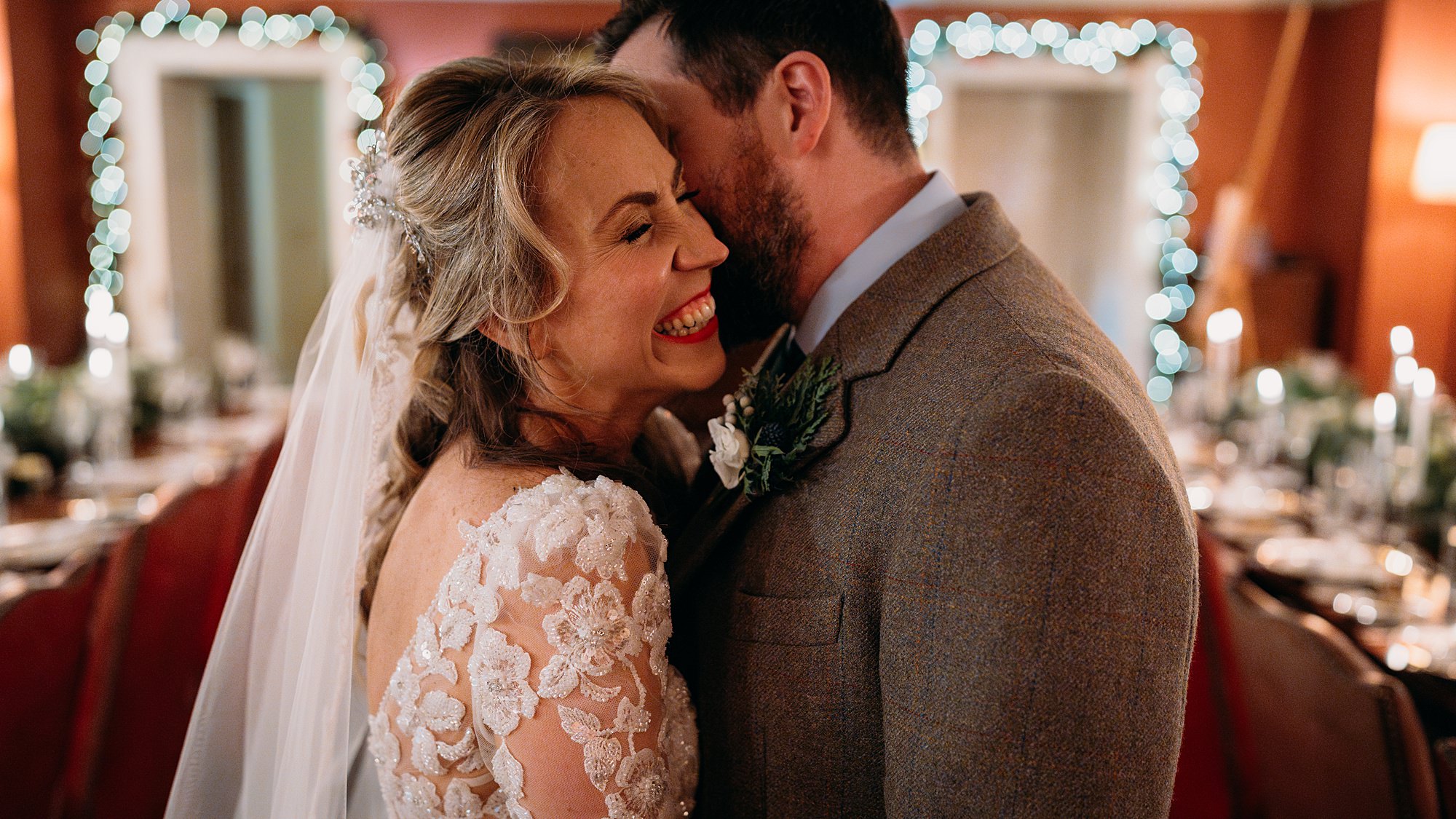 groom kisses brides cheek as she laughs. relaxed Archerfield House wedding photography