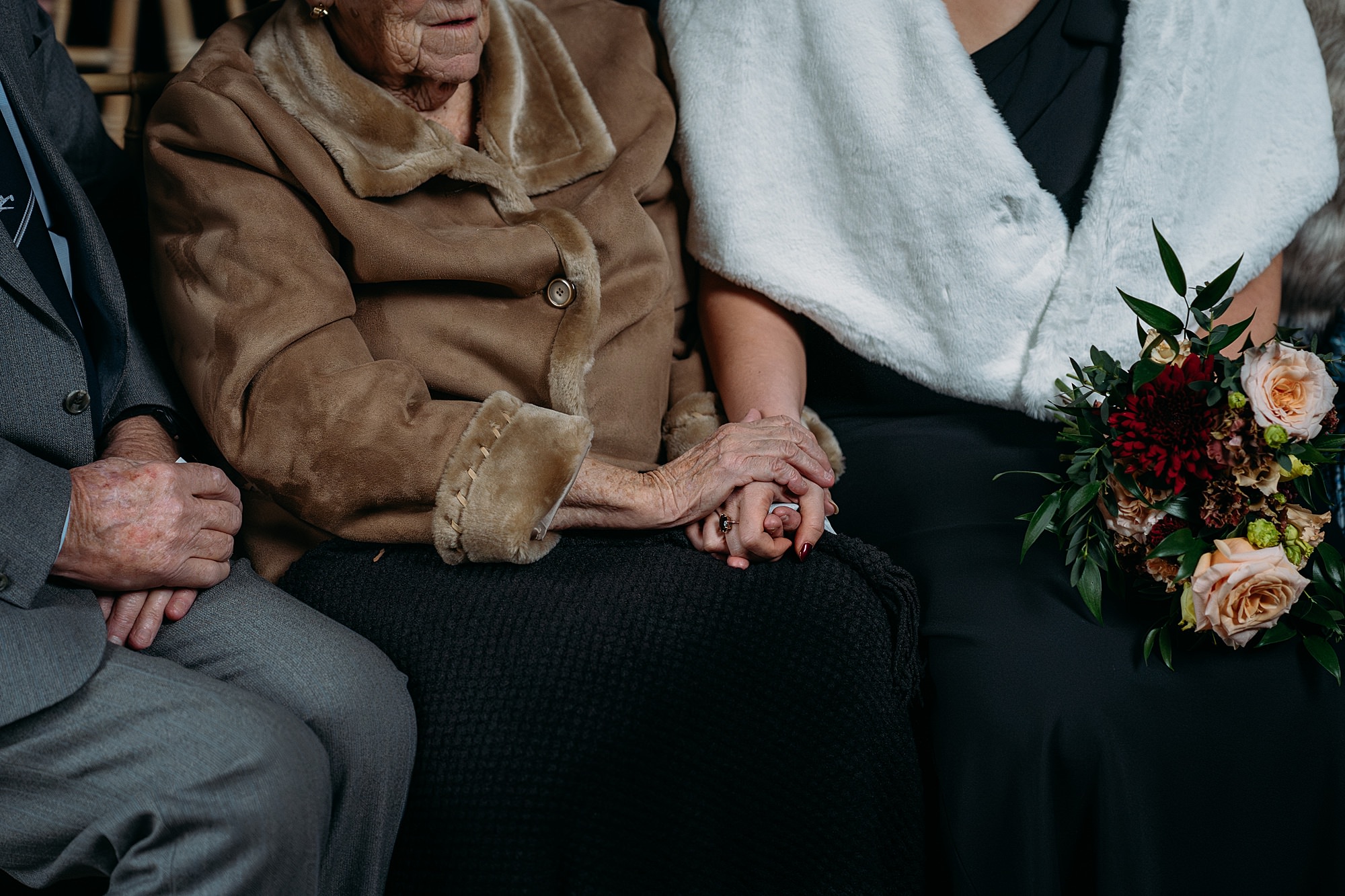 Closeup of grandparent holding adult granddaughters hand. Relaxed wedding photography at Dunglass Estate. 