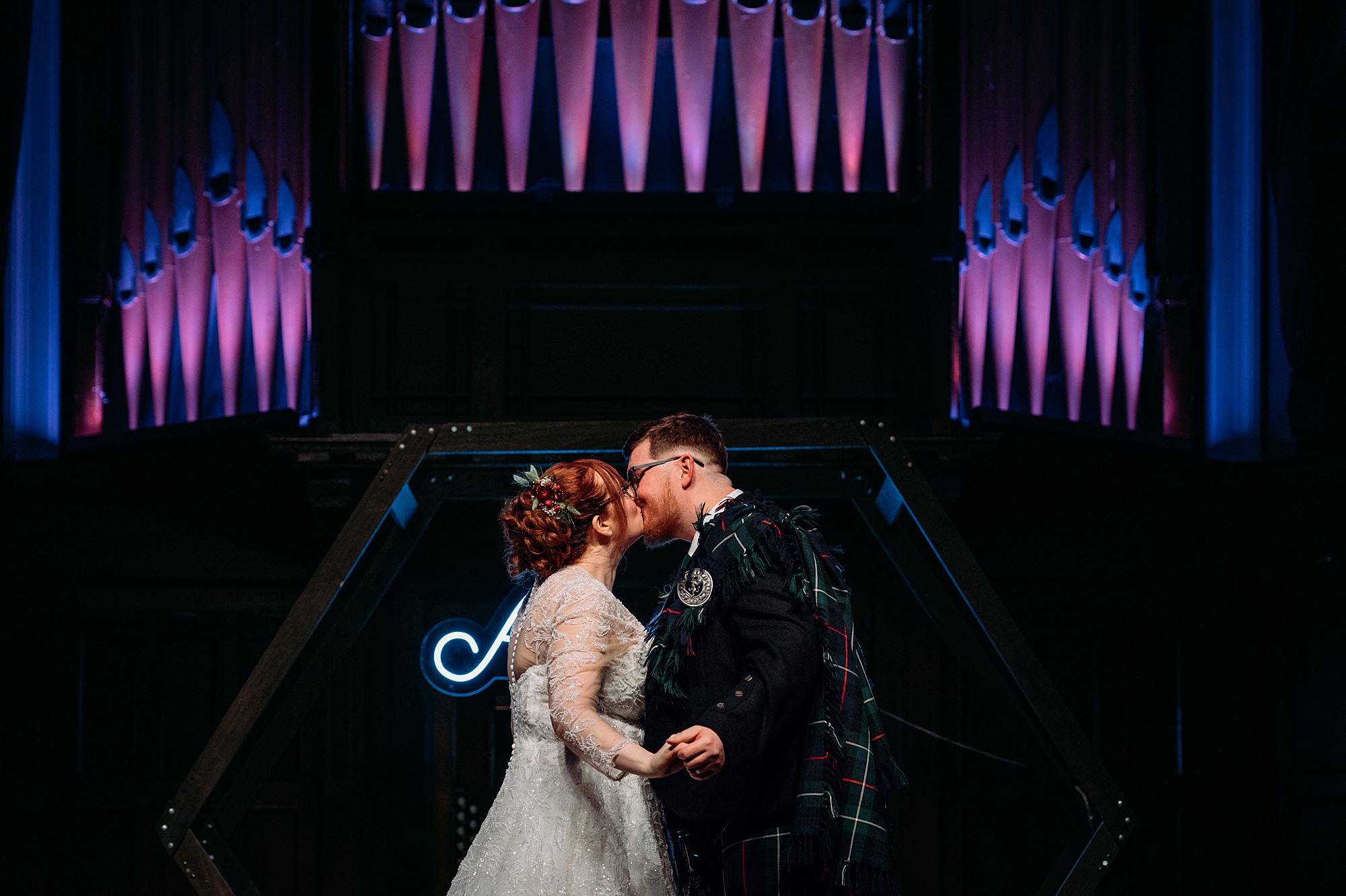 First kiss in bright lights. Relaxed wedding photography at a winter St Lukes wedding.