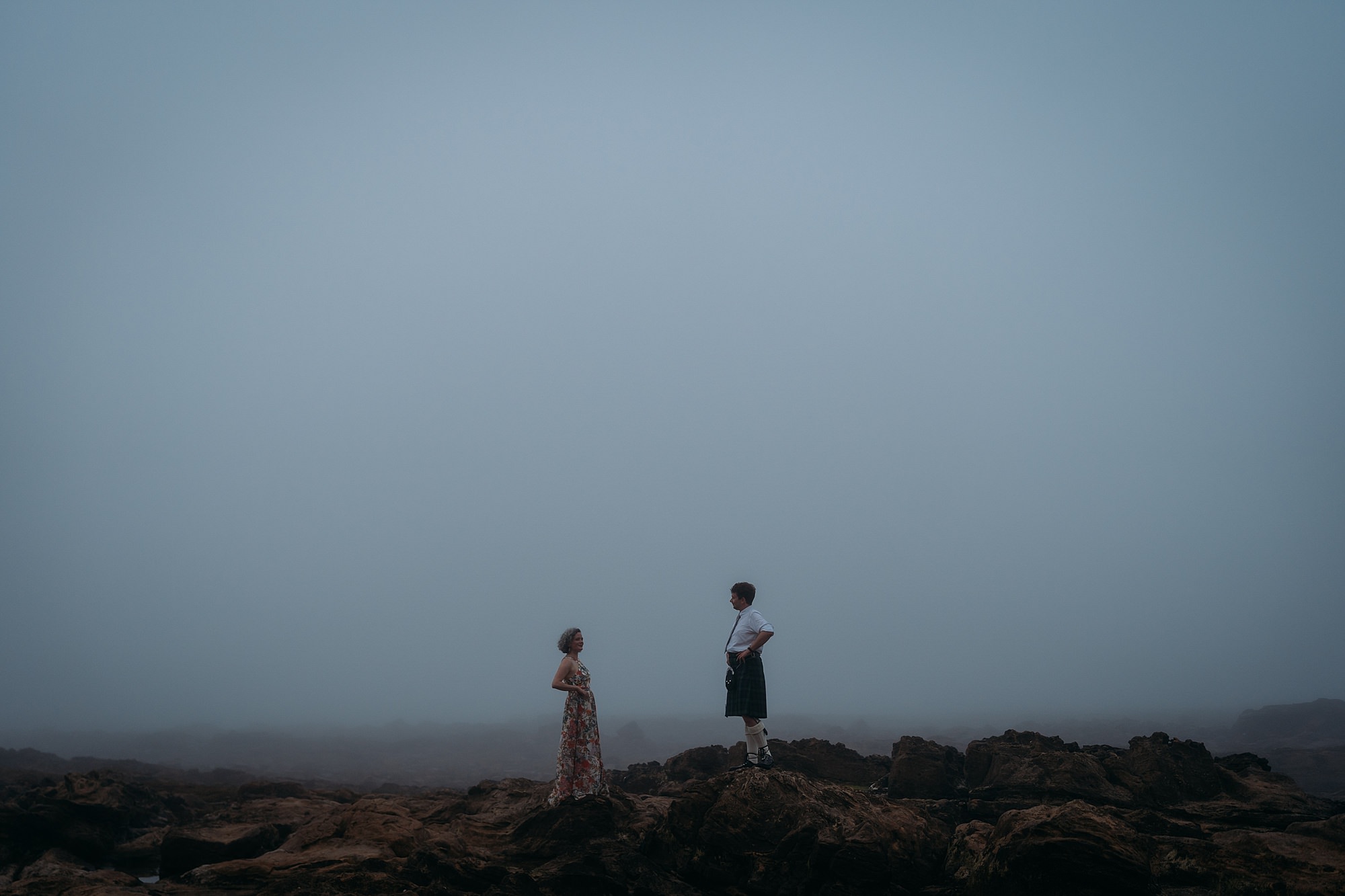 Newlyweds on the beach during blue hour, surrounded by haar. Relaxed wedding photography at Cambo Estate.