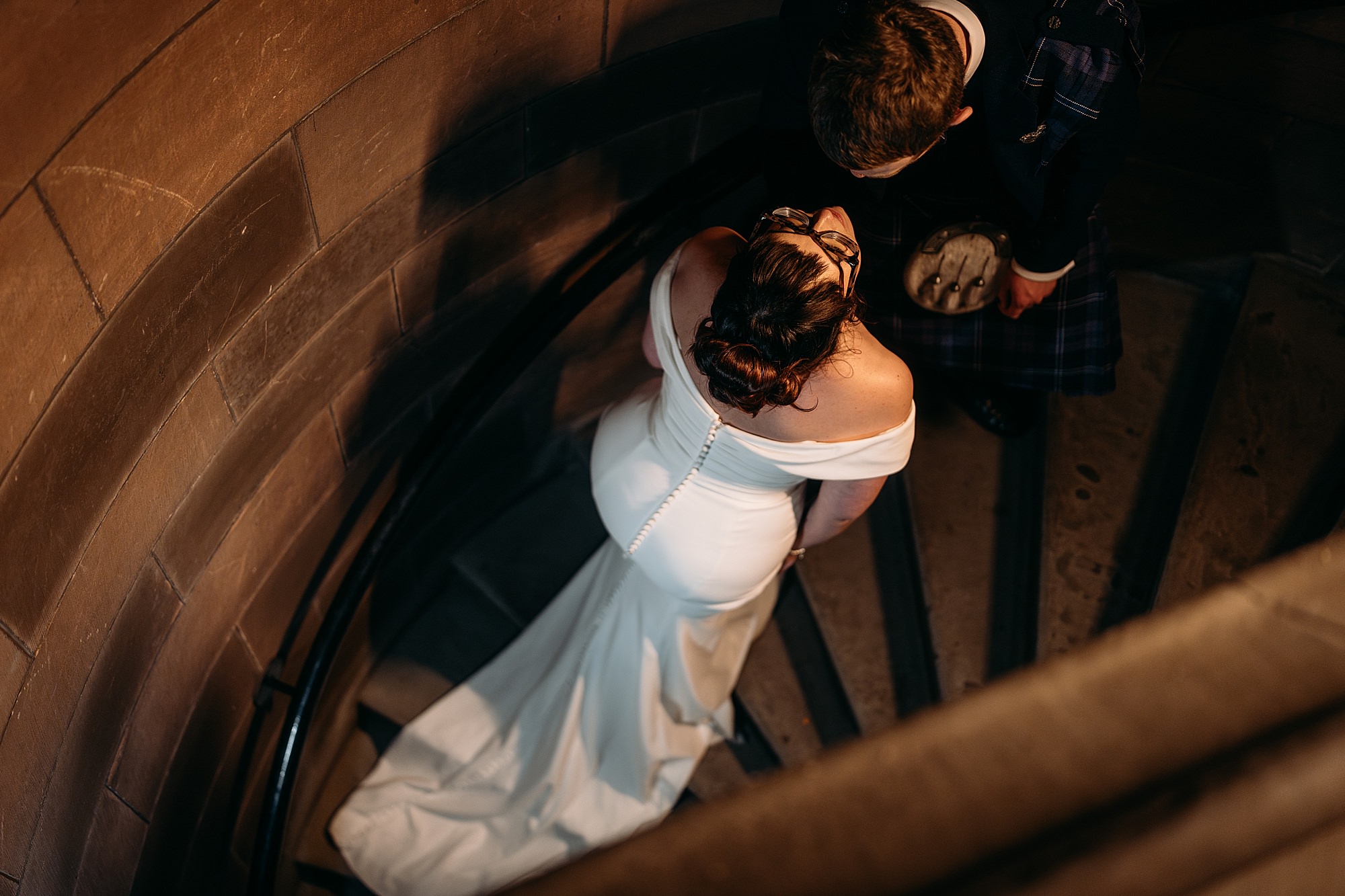 Bride and groom almost kiss on stairs at Coats Paisley Twilight Wedding