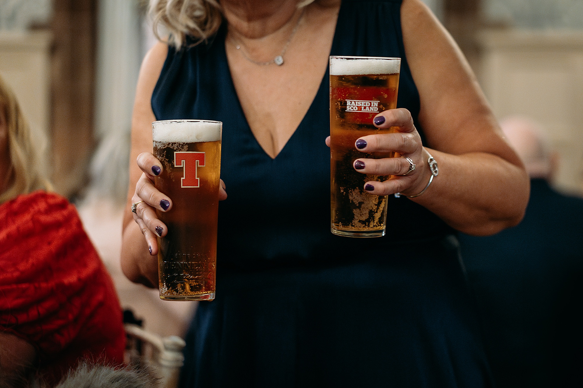Guest holding two pints of Tennents at Coats Paisley Twilight Wedding