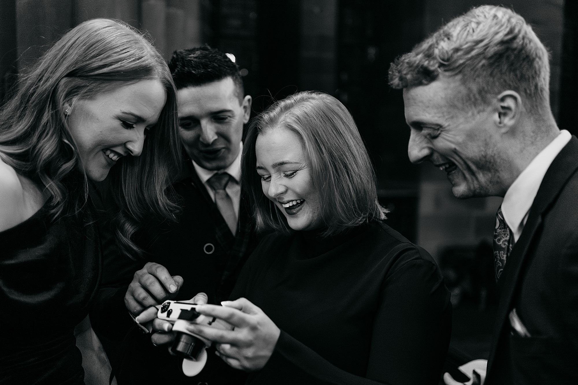 Four friends laugh together at Coats Paisley Twilight Wedding reception