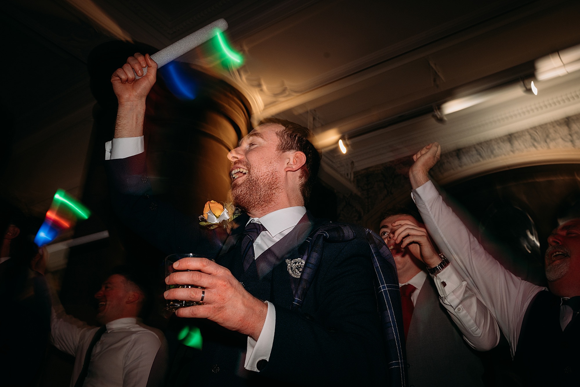 groom dances with glow stick at Coats Paisley Twilight Wedding party