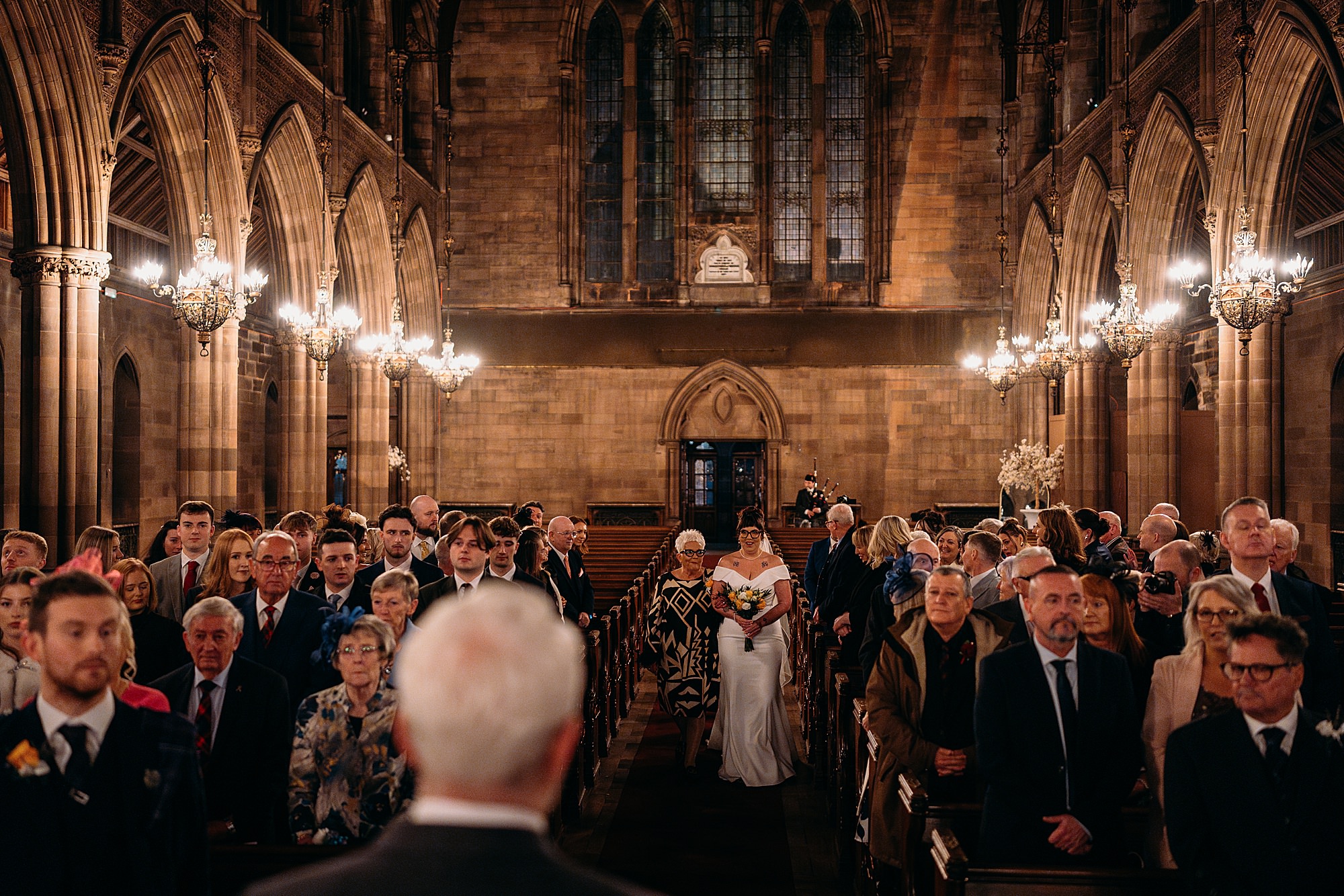 bride walks down aisle with her Mum at Coats Paisley Twilight Wedding