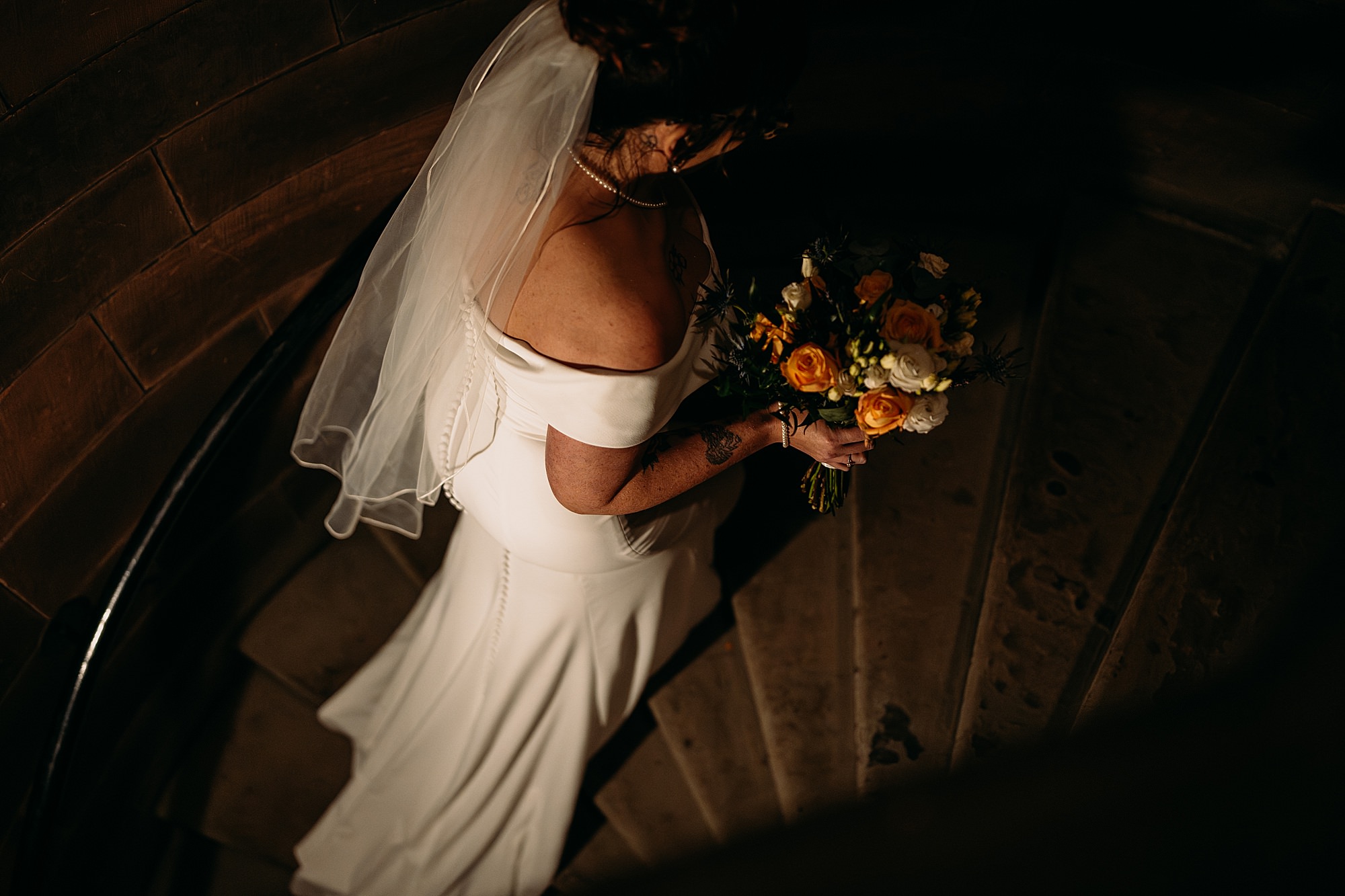 bride walks up the spiral staircase to her Coats Paisley Twilight Wedding