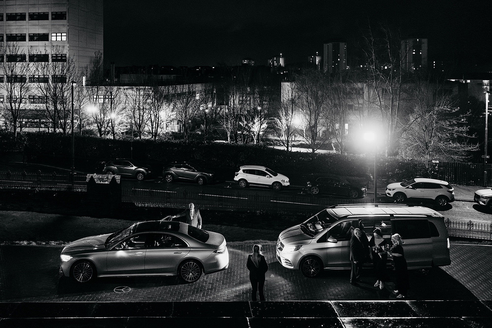 Black and white image of bride arriving for her Coats Paisley Twilight Wedding on a cold and windy night