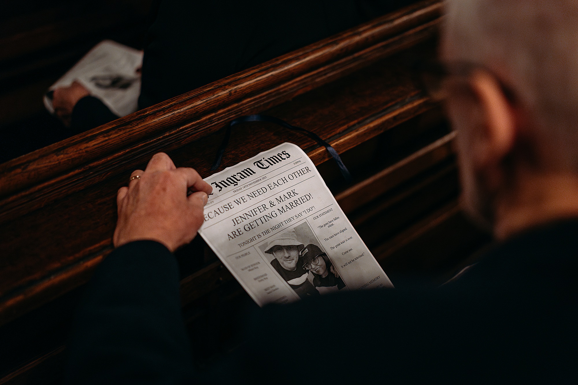 Closeup of hands holding a wedding newspaper at a Coats Paisley Twilight Wedding