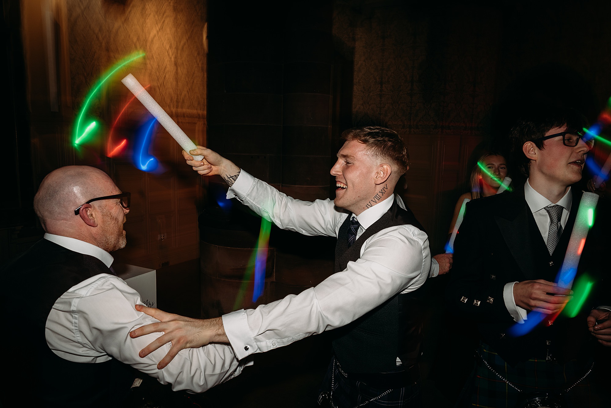 guest hits other guests head with glow stick at Coats Paisley Twilight Wedding party